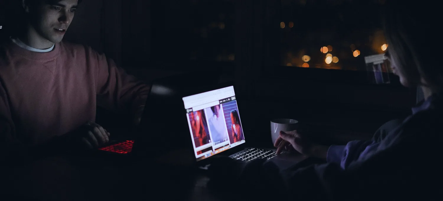 Online poker on a laptop late at night, lit by cool blue screen light